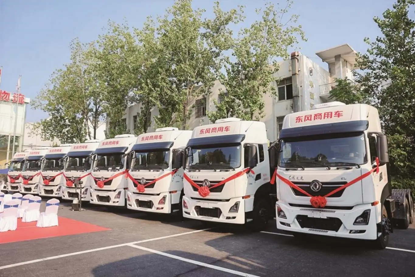 New commercial vehicles wholesale export, aerial photography of truck manufacturing plant with mountain landscape background.