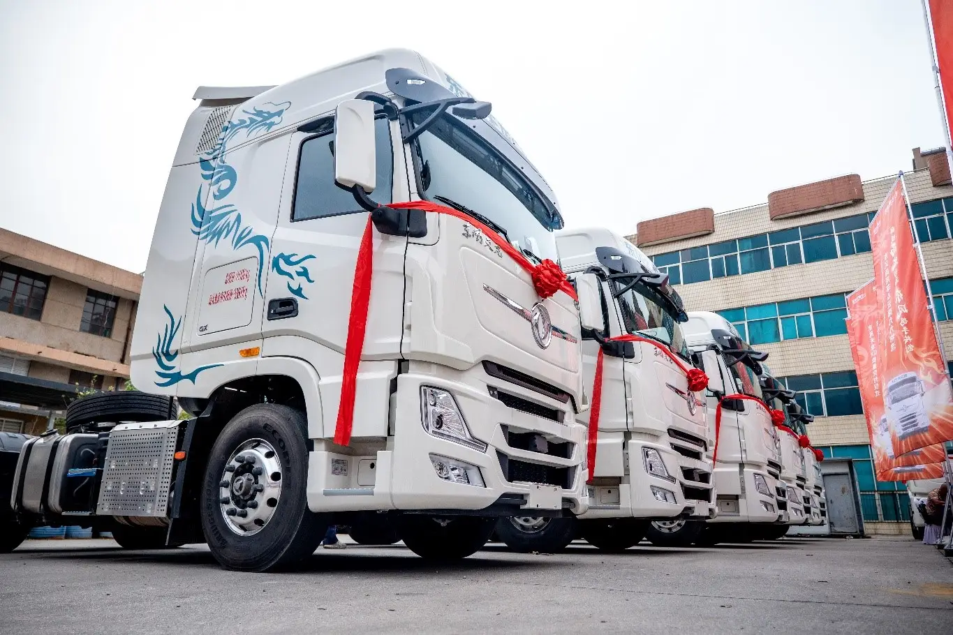 Mass production of heavy - duty trucks at the manufacturing base, a large parking lot full of new commercial vehicles waiting for international delivery.